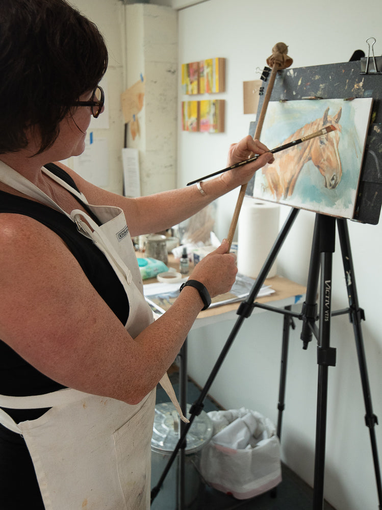 Jennifer Pratt Artist of Horses behind her easel